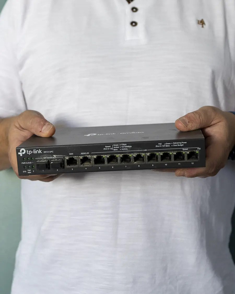 Commutateur réseau Ethernet tenu en main par un technicien ADMIRS.