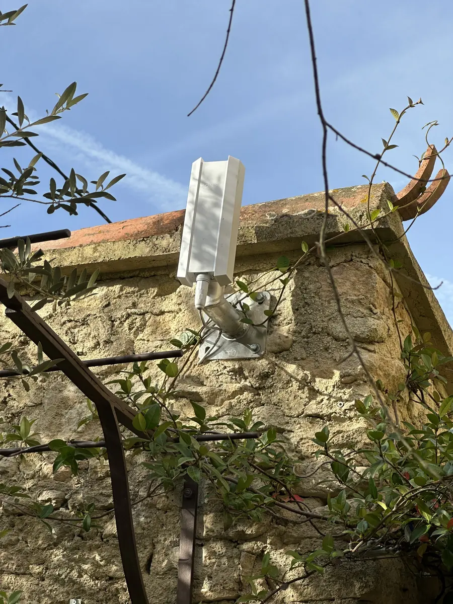 Point d'accès Wi-Fi extérieur installé en façade dans le cadre du déploiement réseau d'un établissement hôtelier.